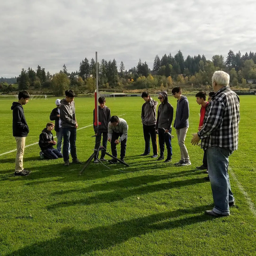 Mentor Bruce Buswell talking with students on a green launch field