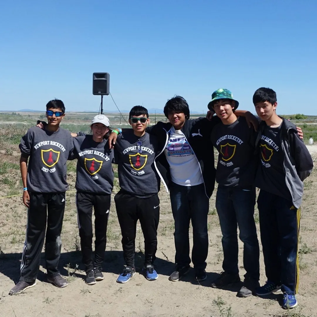 Six club members in matching shirts standing in a dry launch field