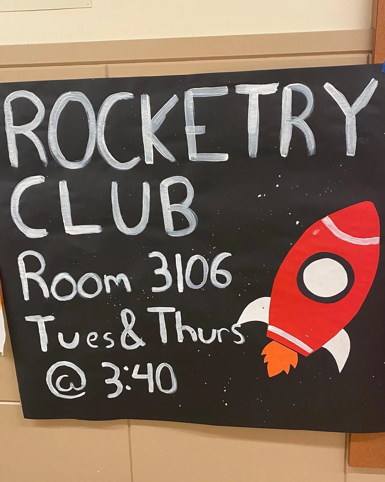 A chalkboard sign reading Rocketry Club