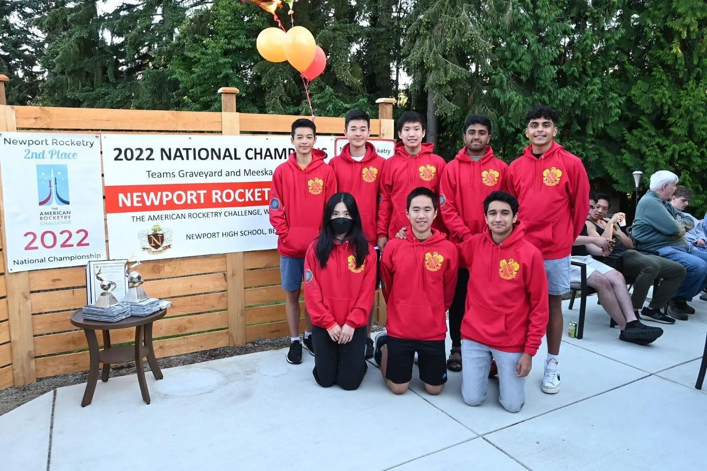 The team in red Boeing hoodies beside a 2022 National Champions banner