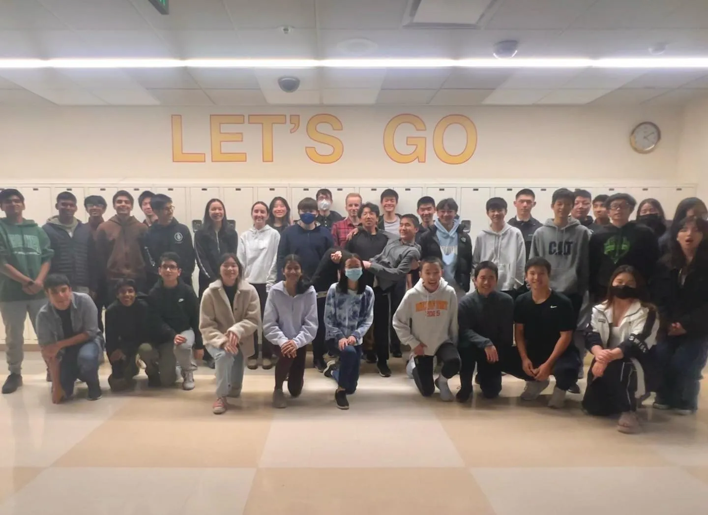 A large group of club members posing together in a school commons