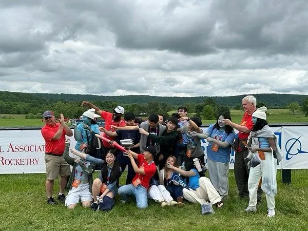 The Newport teams on the grass at Great Meadow under a cloudy sky