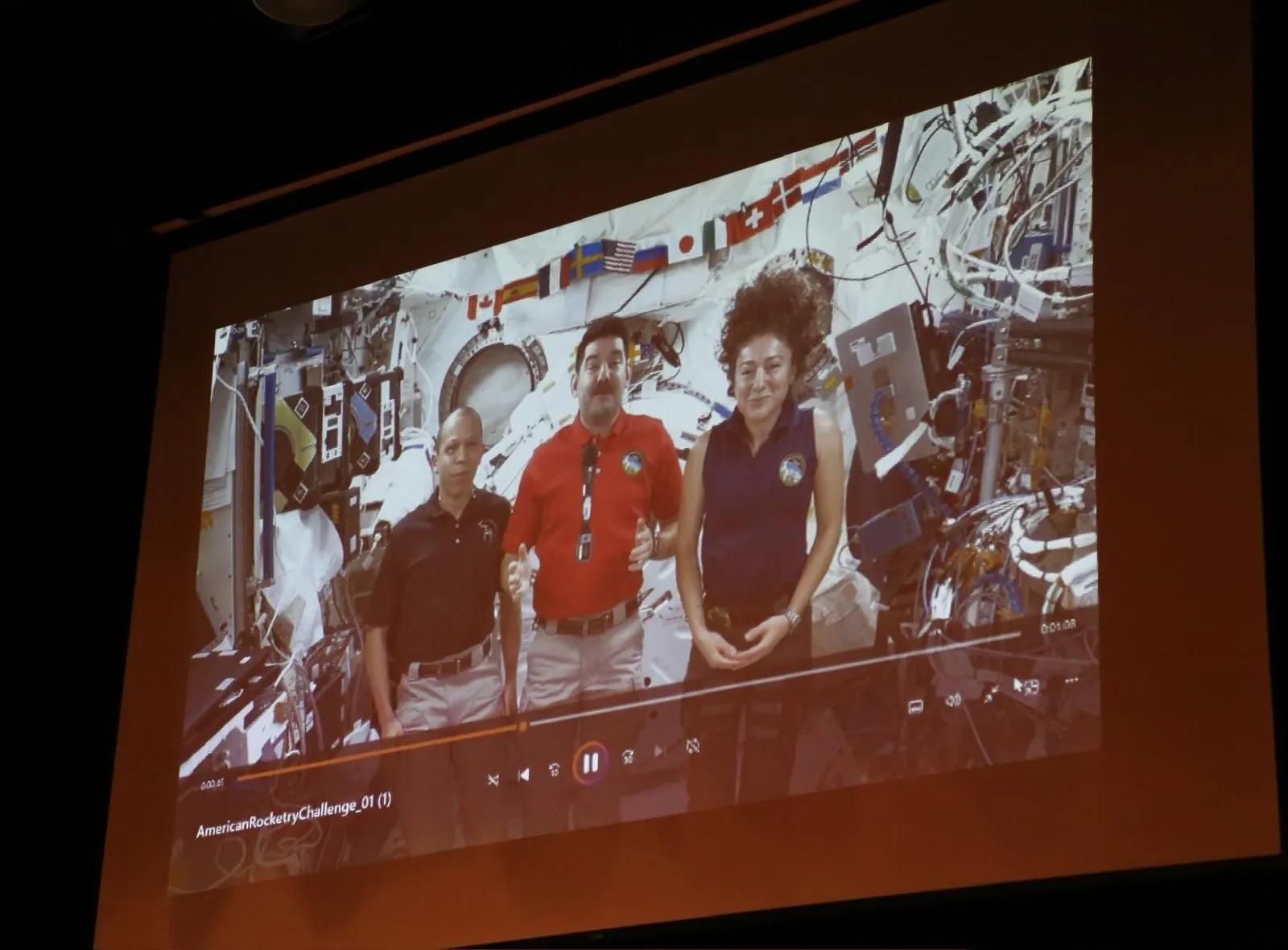 Astronauts aboard the International Space Station on a projection screen