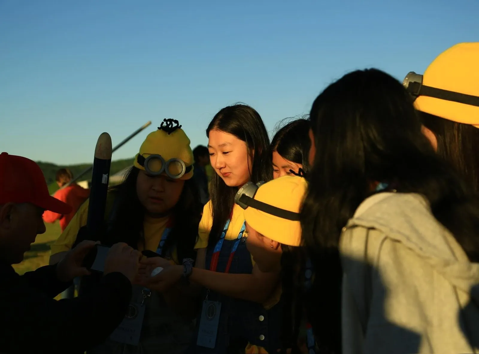 Team members silhouetted against a sunset at the finals